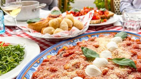 Composizione di piatti tipici de La Basilica, inclusa la focaccina con cecina e la pizza Leonardo, e altri antipasti