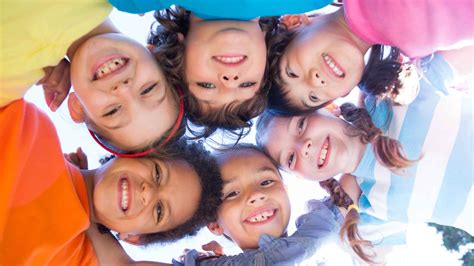 Bambini che sorridono, con volti luminosi e fiduciosi, in un contesto di gioia e fede