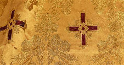 Vesti liturgiche con ricami in oro su sfondo colorato, mostrando la ricchezza e la cura dei dettagli