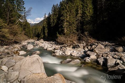 Pietro che raccoglie acqua da un torrente di montagna
