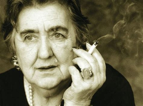 Ritratto intenso di Alda Merini, pensierosa, con una candela accesa