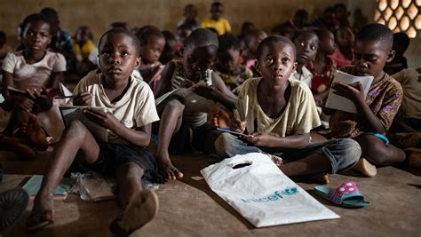 Foto di bambini in Congo che giocano a calcio con le maglie donate, simbolo di gioia e solidarietà.