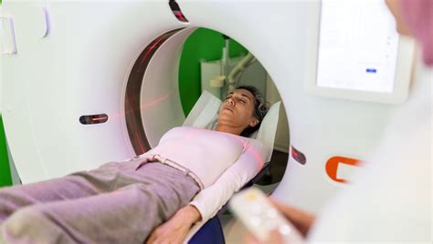 Inforgrafica che mostra il funzionamento di una TAC a conta fotonica, oppure foto di una moderna sala di diagnostica per immagini.