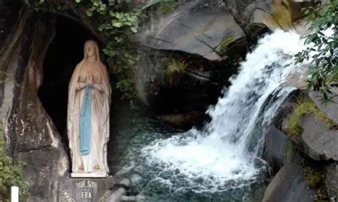 Pellegrini che si immergono nelle piscine di acqua di Lourdes