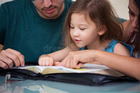 Famiglia che legge insieme la Bibbia, bambini e genitori