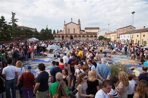 Madonnari all'opera sul sagrato del Santuario, intenti a creare opere effimere con gessetti colorati.