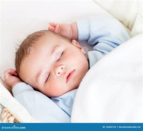 Bambino che dorme con un doudou e una lucina notturna nella sua culla