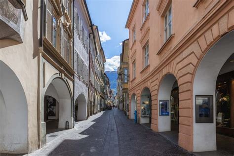 Foto panoramica di Via dei Portici a Merano con i suoi negozi e facciate storiche