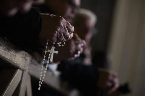 Gruppo di fedeli in preghiera, recitando il Rosario insieme
