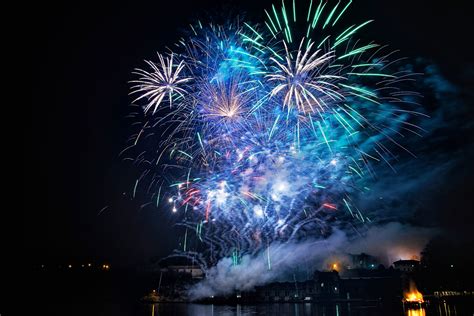 Spettacolo pirotecnico sopra il mare, con riflessi sull'acqua.