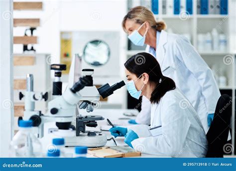 Giovani ricercatori in laboratorio o durante una sessione di studio con microscopi e provette