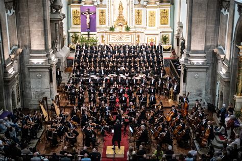 Coro polifonico accompagnato da una band rock durante un'esibizione dal vivo in un contesto parrocchiale