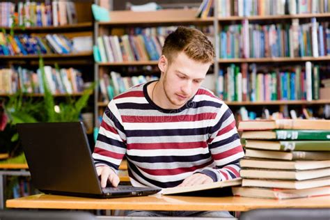 Giovane sacerdote salesiano che studia in una biblioteca