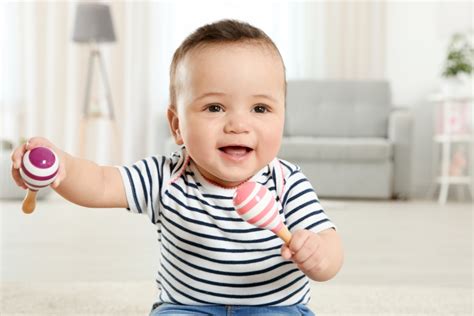 Bambino che gioca con un sonaglio in argento