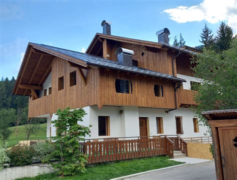 Esterno dell'Hotel Quadrifoglio in stile montano con sfondo alpino