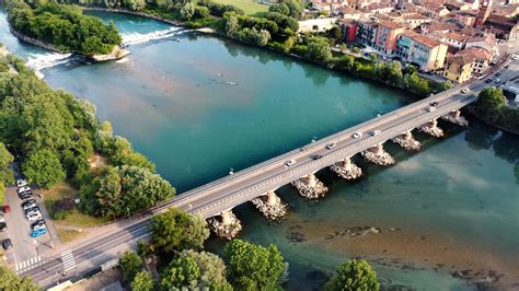 Vista panoramica del fiume Adda con vegetazione lussureggiante e sentieri pedonali