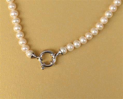 Collana d'oro con ciondolo a croce e orecchini di perle