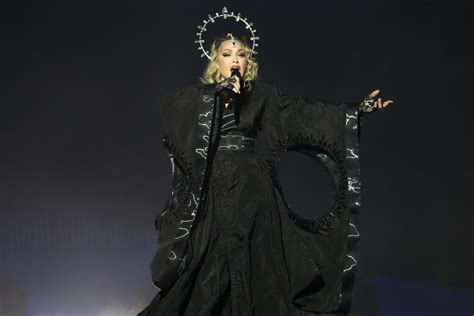 Madonna sul palco durante il Celebration Tour, con un costume scintillante e un'espressione energica