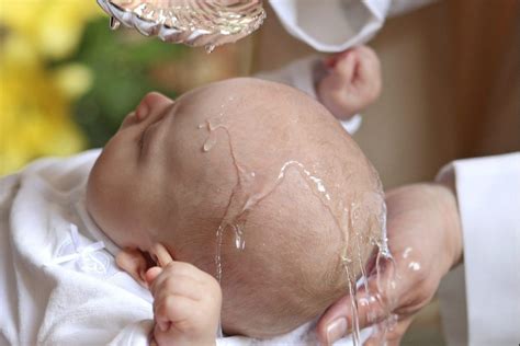 fotografia di un bambino che riceve il battesimo