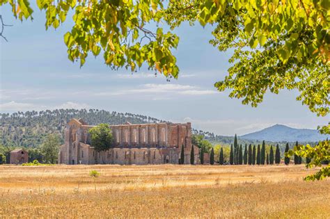 Foto panoramica dell'Abbazia di San Galgano immersa nella campagna toscana con colline e cipressi