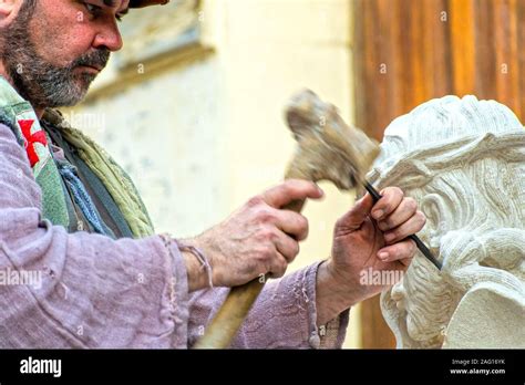 Scultore artigiano mentre intaglia un presepe a blocco in un laboratorio della Val Gardena