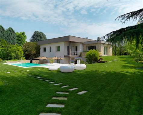 Esempio di villa moderna con ampio giardino curato e zona solarium