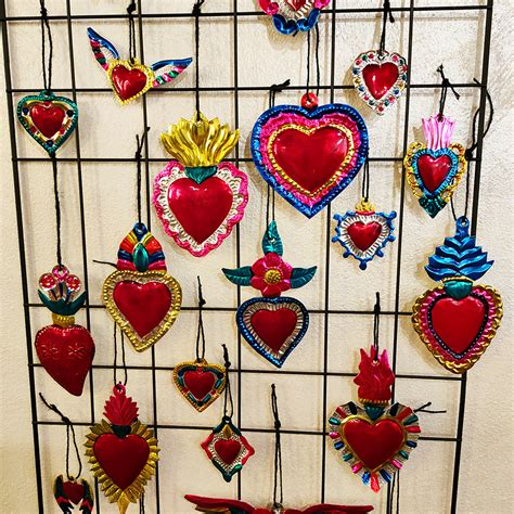 Dettaglio ravvicinato di un cuore ex voto in ottone inciso a mano con motivi barocchi
