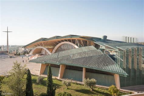 Foto aerea della Chiesa di Padre Pio e del sagrato, evidenziando la forma a conchiglia e l'integrazione nel paesaggio.