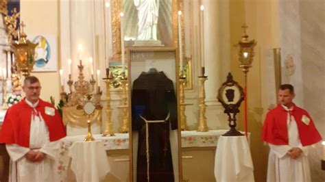 Foto di fedeli in preghiera davanti all'altare dove sono esposte le reliquie di Padre Pio.