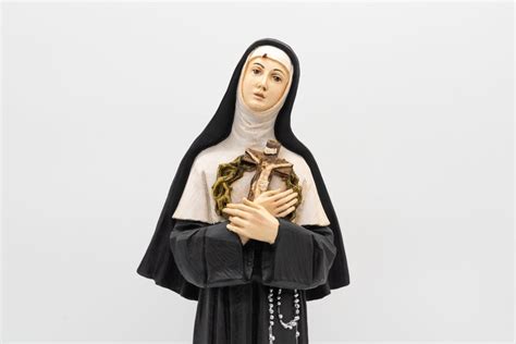 Set completo di articoli religiosi dedicati a Santa Rita: statua, rosario, collana e candele votive