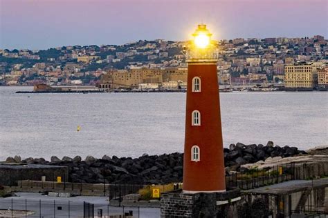 Foto di un faro che illumina il mare al crepuscolo, simbolo di guida e speranza