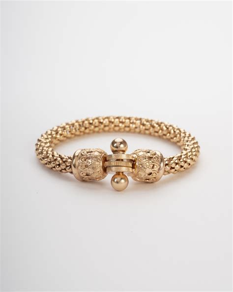 Dettaglio di un bracciale in oro raffinato su sfondo neutro
