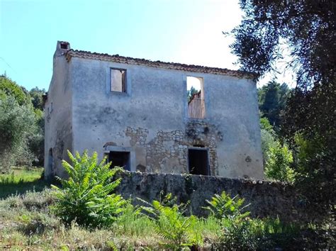 Rendering o foto di un casale antico da ristrutturare con terreno