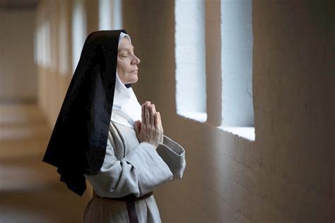 Foto tematica di assistenza religiosa o una suora in preghiera in ambiente ospedaliero.
