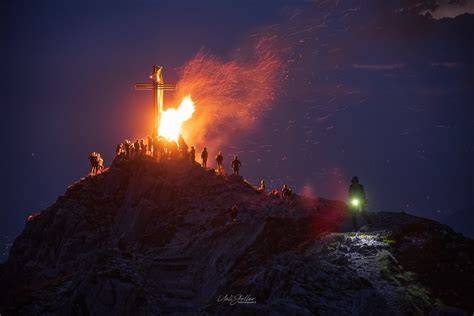 Fuochi del Sacro Cuore di Gesù sulle montagne dell'Alto Adige al tramonto