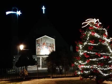 Sacerdote che celebra con bambini in una chiesa addobbata per la festa