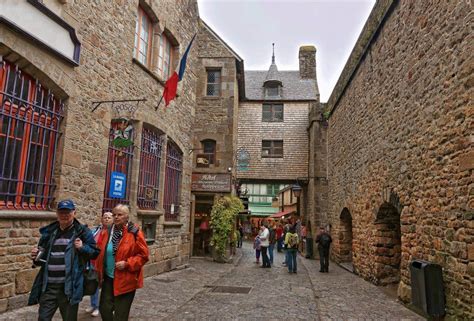 Vicolo medievale nel borgo di Mont Saint-Michel con negozi caratteristici