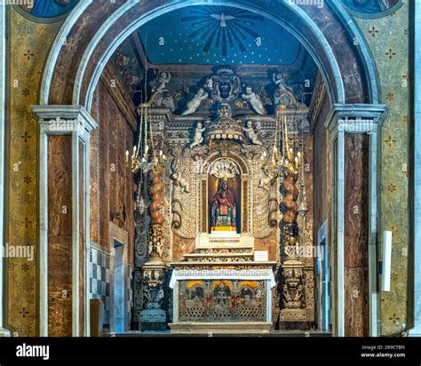 Interno di un antico santuario mariano con ricche decorazioni a stucco, altare maggiore in marmo policromo e statue