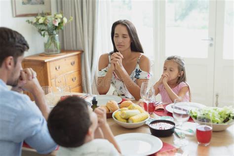Famiglia che prega davanti a un'immagine del Sacro Cuore in casa