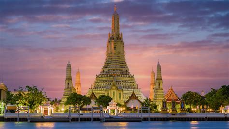 Wat Arun al tramonto con riflesso sull'acqua