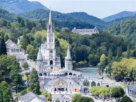 Foto panoramica di Lourdes con il Santuario e le montagne dei Pirenei sullo sfondo