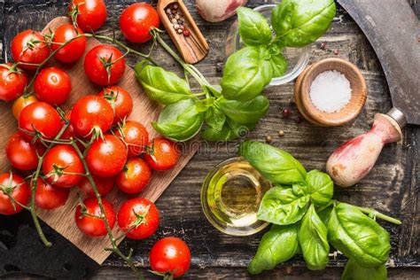 Cesto di pomodorini freschi con foglie di basilico su un tavolo rustico