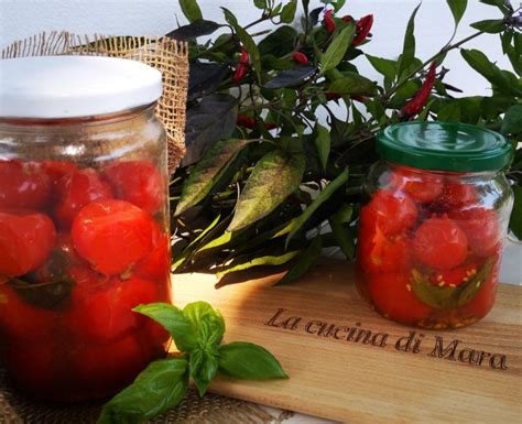 Vasetti di vetro riempiti con pomodorini interi, basilico e aglio