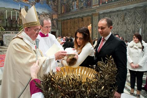Papa Francesco mentre amministra il sacramento del Battesimo a un bambino nella Cappella Sistina