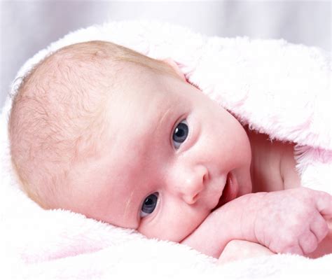 Foto di un neonato in abito battesimale