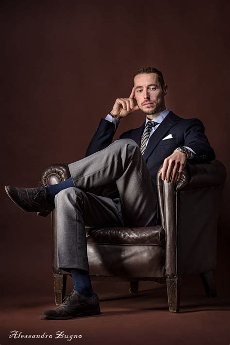 foto di un uomo elegante in completo che tiene in braccio un neonato durante un battesimo