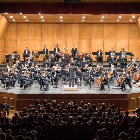 Foto di un'orchestra sinfonica sul palco con pubblico in sala