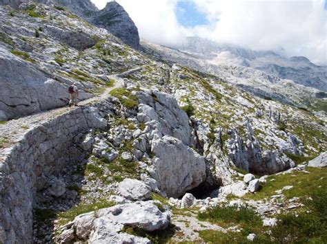 Sentiero impervio che porta verso una luce, simbolo del percorso di fede attraverso le difficoltà