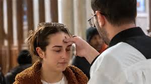 Rappresentazione di un sacerdote che impone le ceneri sulla fronte di un bambino