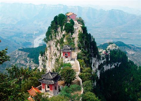 Vista panoramica della cima del Monte Taishan con i suoi templi e la vegetazione circostante.